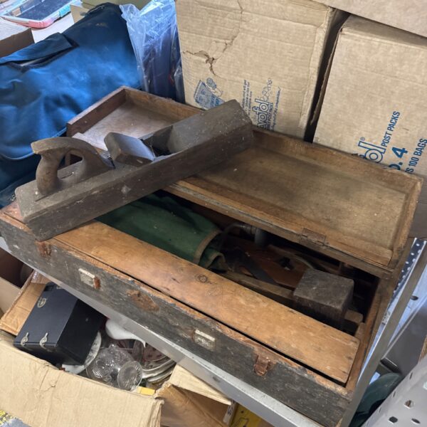 Vintage carpenter's toolbox filled with various antique tools.