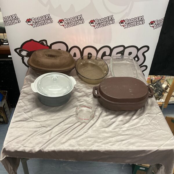 Vintage cast iron casserole dishes and glass baking dishes on display.