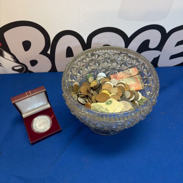 Vintage coin lot with Viyella cup match medal displayed.