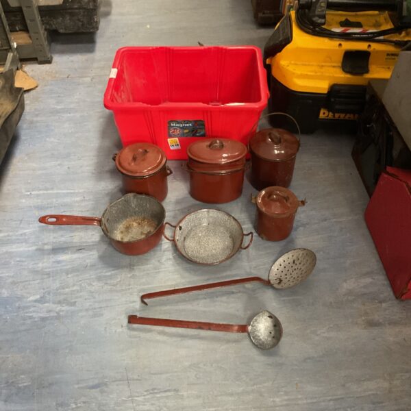 Vintage copper pots and pans with enamel coating on display.