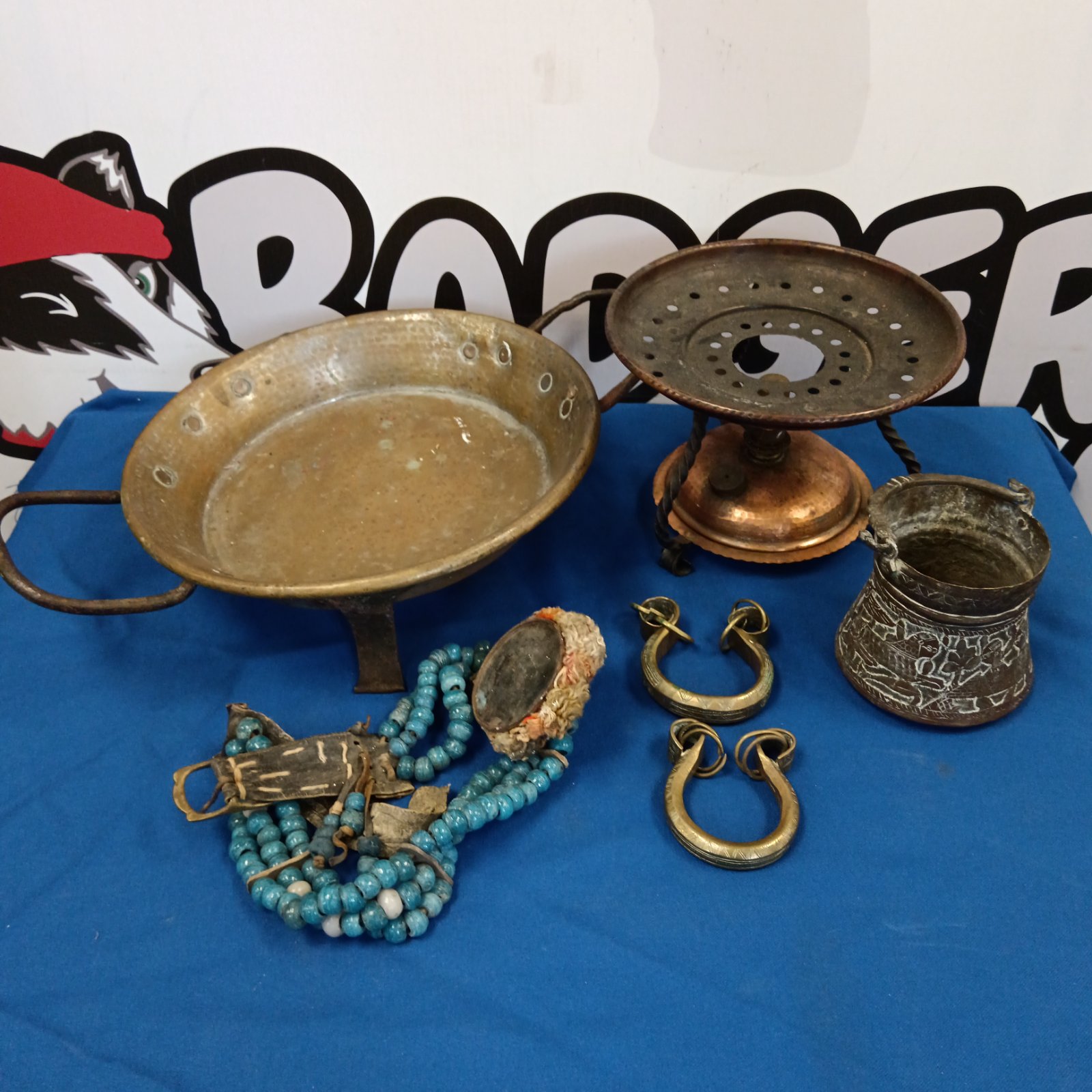 Vintage copper pan with African bangles, antique kitchenware and tribal jewelry.