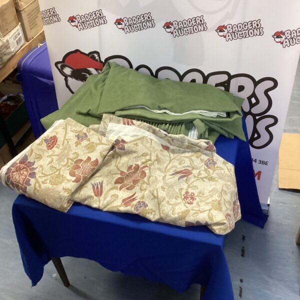 Vintage floral and olive green curtains displayed on a table.