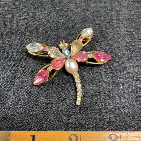 Close-up of a vintage dragonfly brooch with colourful rhinestones.