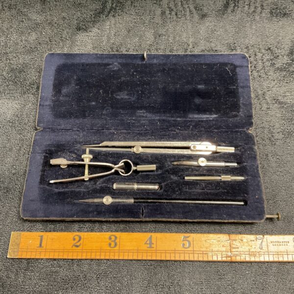 Vintage drawing instrument set with compass and pen.