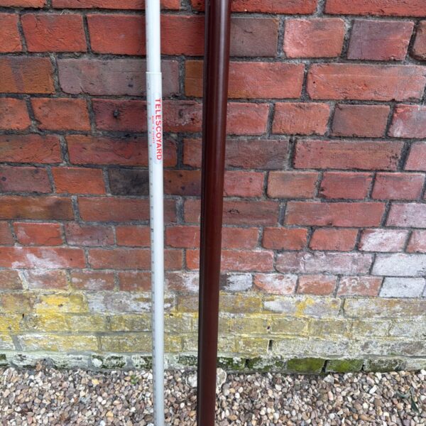 Vintage French surveying pole with telescopic sections and measurement markings.
