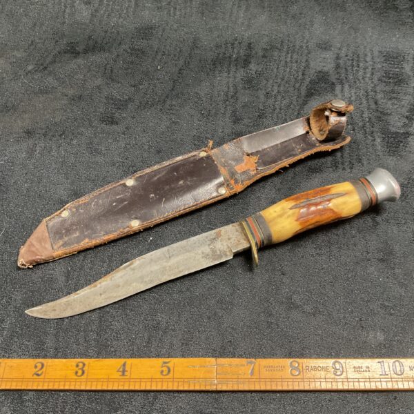 Vintage horn handle knife with leather sheath, collectible fixed blade.