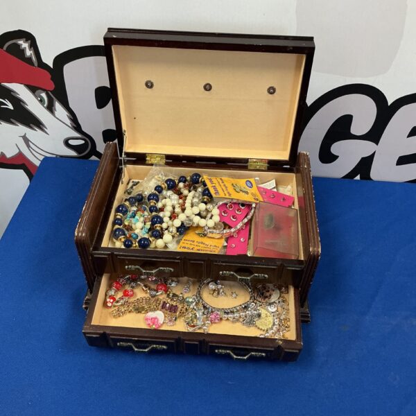 Vintage wooden jewellery box filled with costume jewellery.