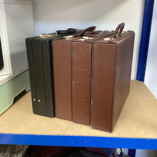 Group of four vintage brown and black leather briefcases.