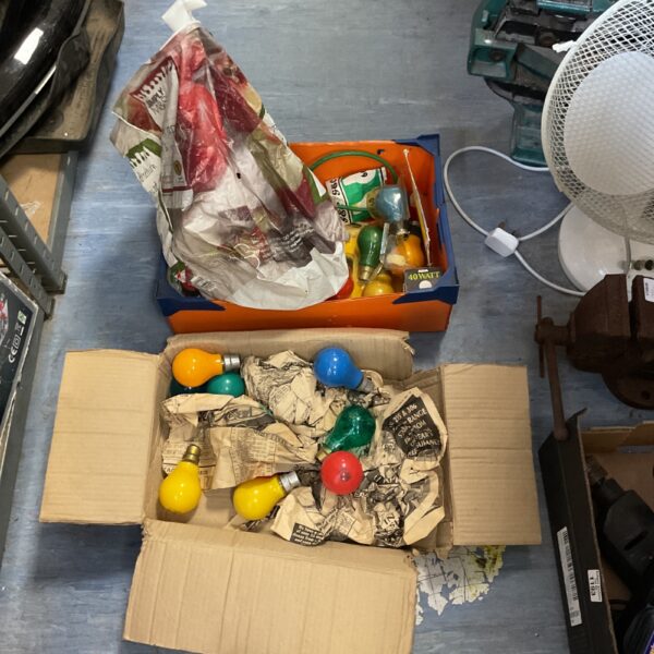Collection of colourful vintage light bulbs in a cardboard box.