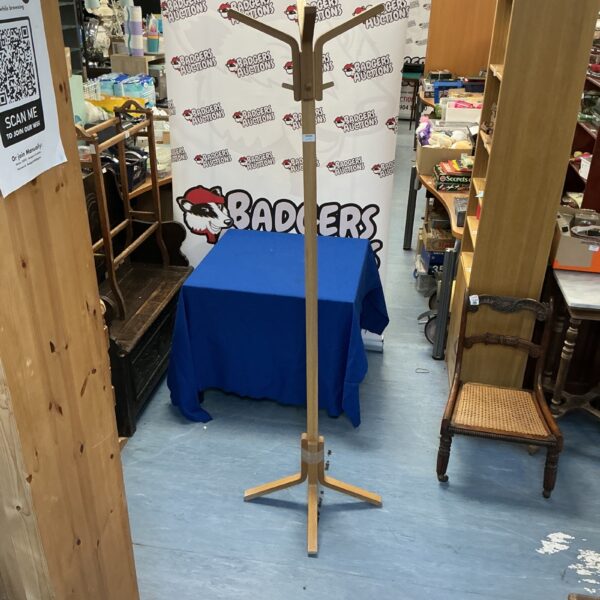 Vintage light wood coat stand with multiple hooks for coats.