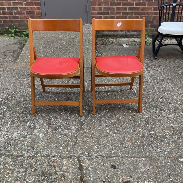 Pair of vintage Ligna folding chairs with red vinyl seats.