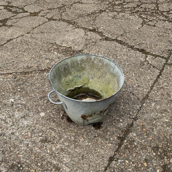 Vintage metal planter bucket with rustic patina.
