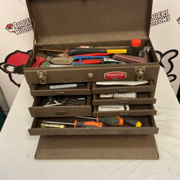 Vintage metal tool box filled with tools, front view.