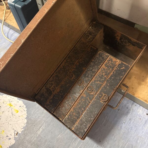 Vintage metal toolbox with open drawers for tool storage.