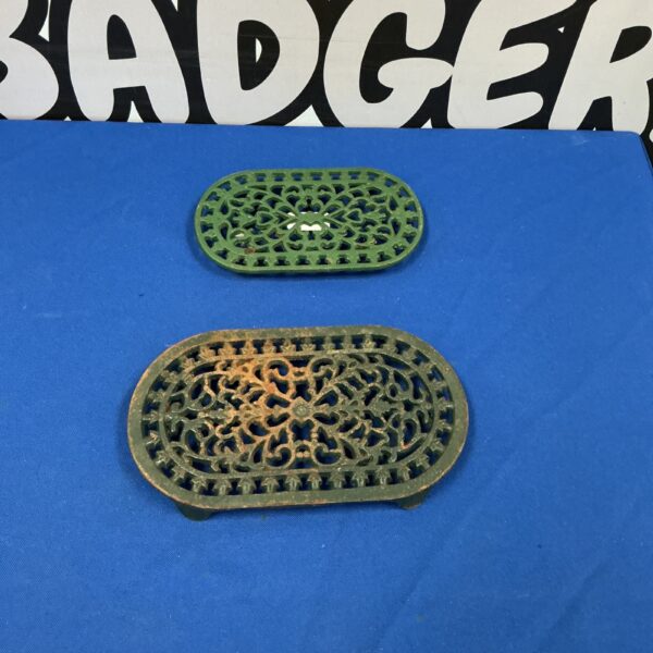 Intricate vintage metal trivet with floral design.