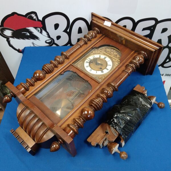 Vintage oak wall clock with pendulum and Roman numeral face.