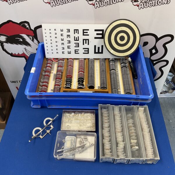 Vintage optometrist testing kit with trial lenses and eye chart.