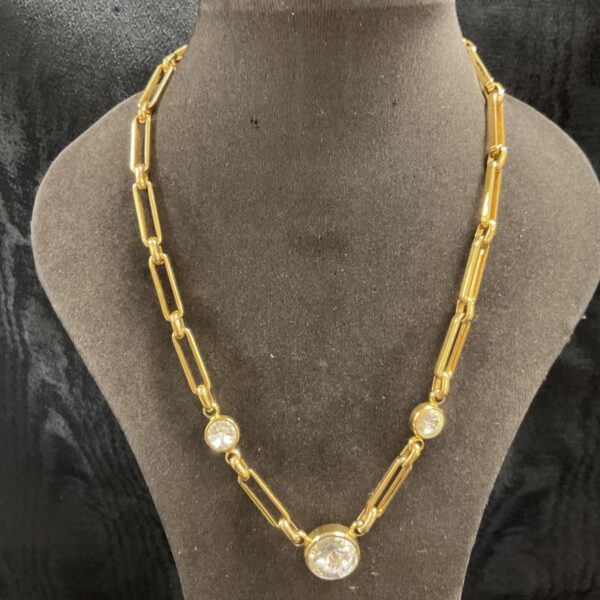 Vintage gold tone paperclip necklace with clear bezel set stones.