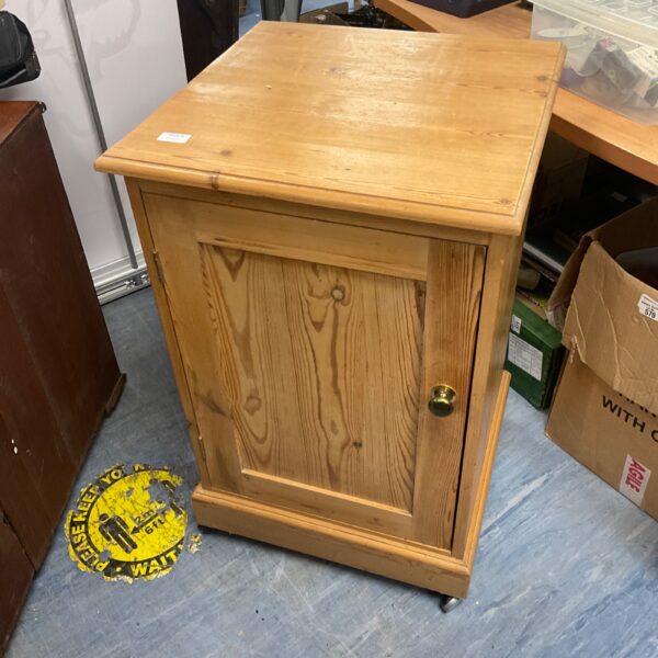 Vintage pine cabinet with a single door, rustic storage solution.