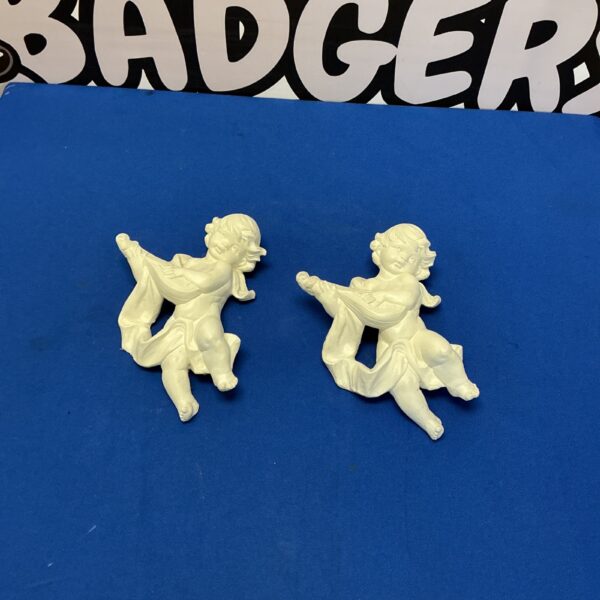 Vintage plaster cherubs for wall decor, charming angelic figures.