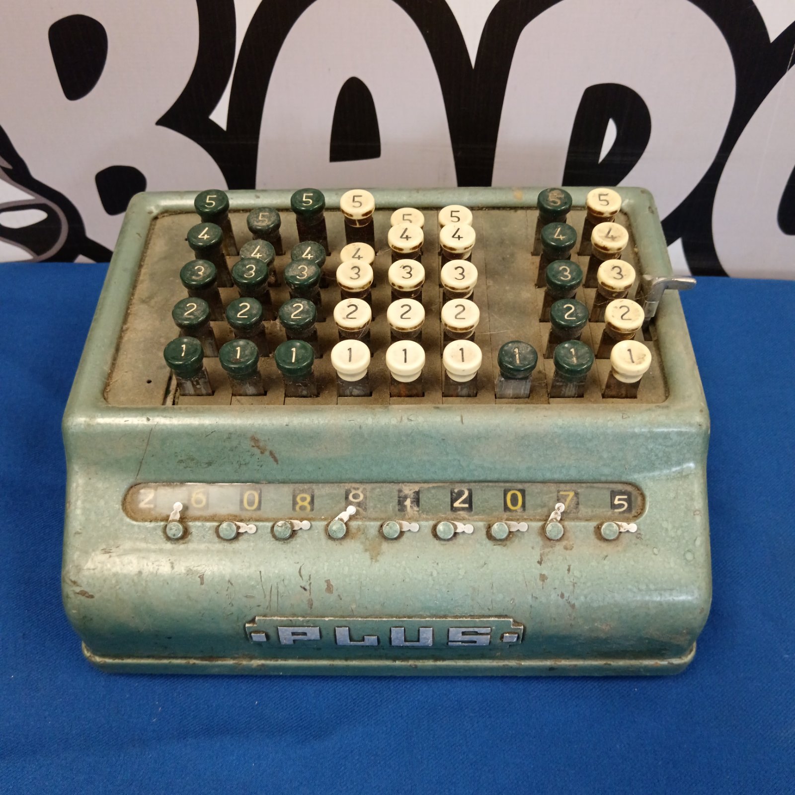 Front view of a vintage Plus mechanical calculator.