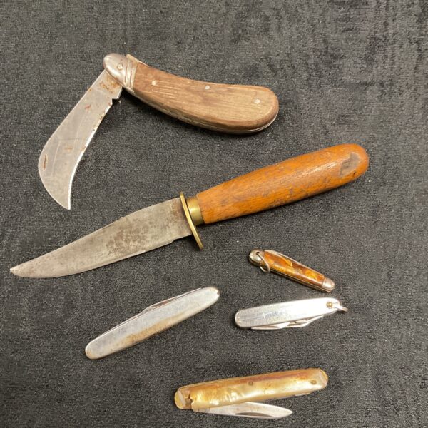 Vintage pocket knife collection with bone and wood handles.
