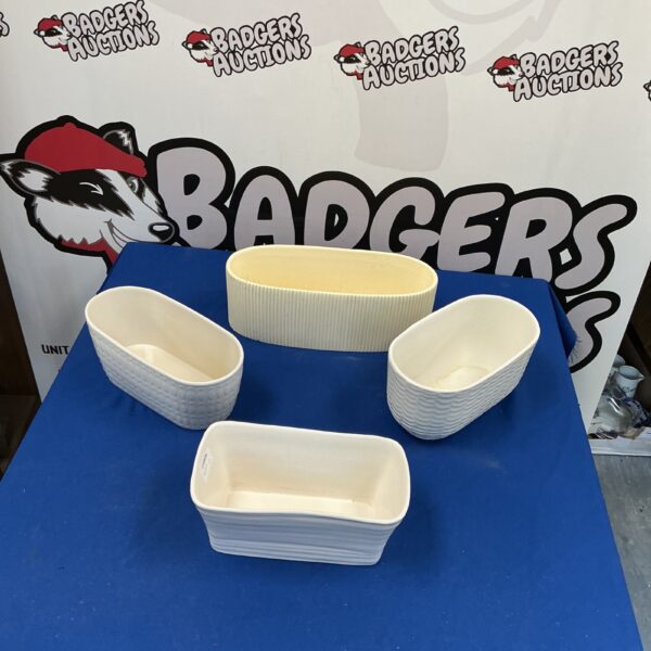Vintage porcelain flower holders displayed on a surface.