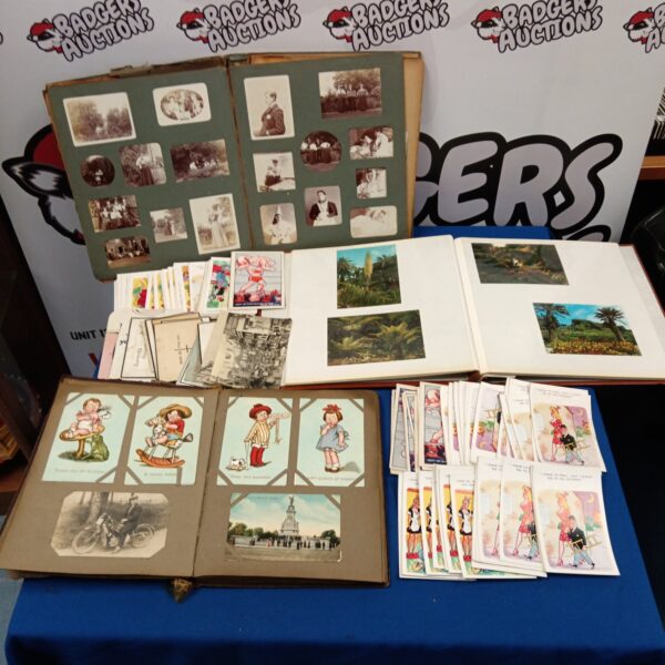 Overview of a vintage photograph and postcard collection on a blue table.