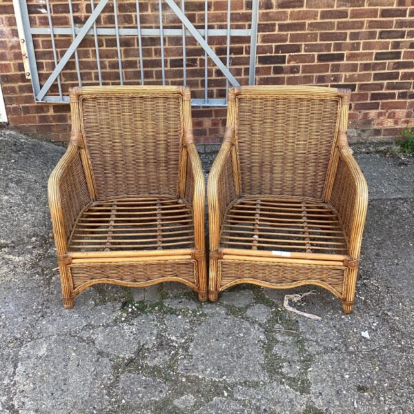 Pair of vintage rattan armchairs with woven wicker design.