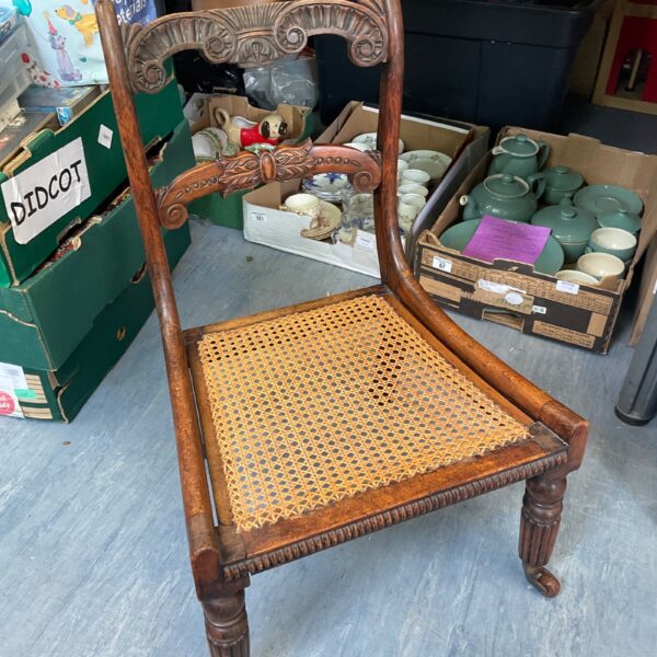 Side view of a vintage rattan chair with woven seat.