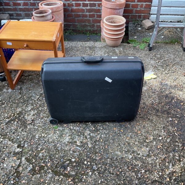 Vintage Samsonite hard-shell suitcase in a garden setting.