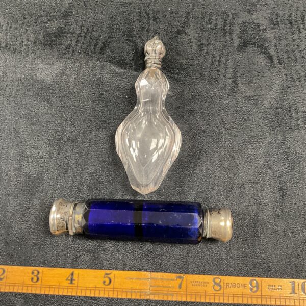 Pair of vintage glass scent bottles, one clear and one blue.