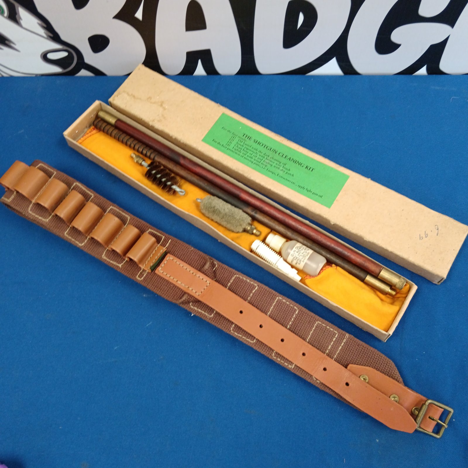 Vintage shotgun cleaning kit and cartridge belt displayed open.