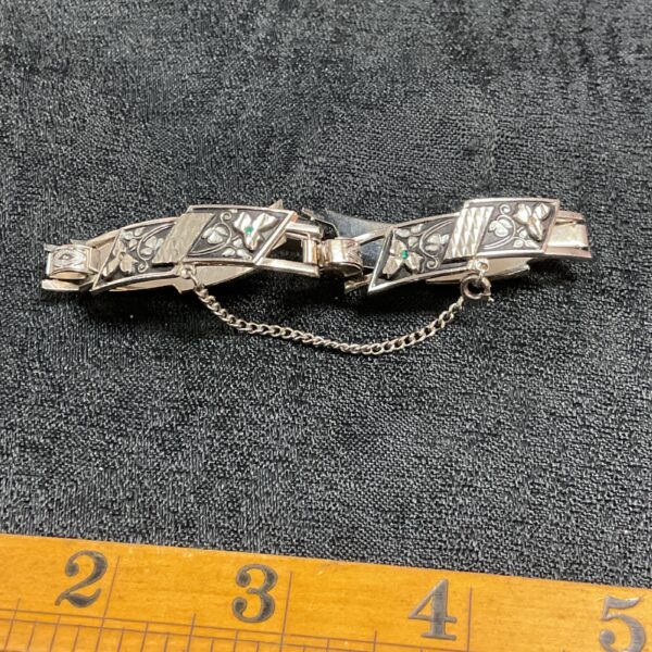 Vintage silver tone bracelet with green stones and floral design.