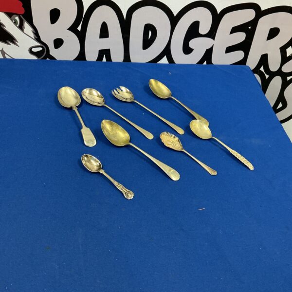 Vintage silverplate spoons with detailed handles, antique cutlery.