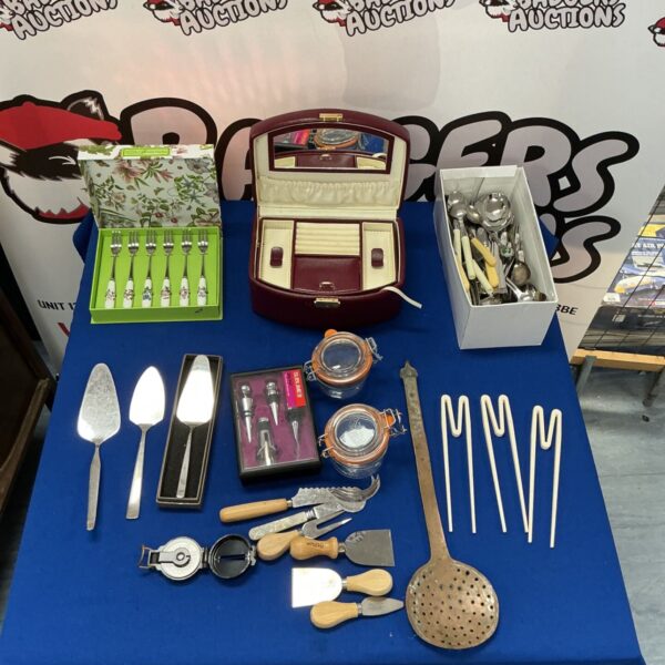 Vintage silverware set with spoons, forks, and chopsticks on display.
