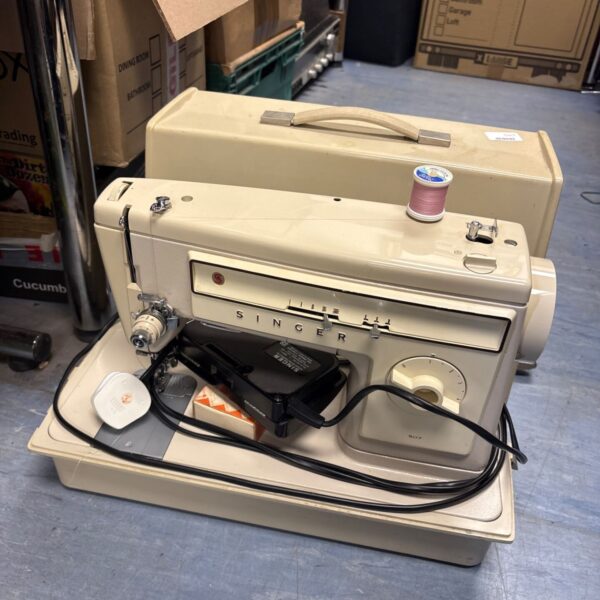 Vintage Singer sewing machine with case, showing wear and tear.