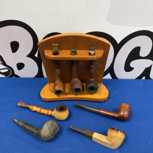 Vintage smoking pipes displayed on a wooden rack.