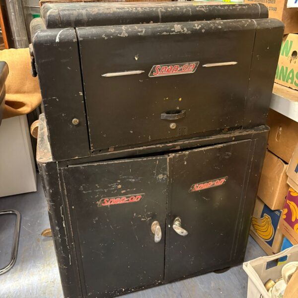 Vintage Snap-On tool cabinet in dark green, showing wear and tear.