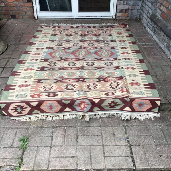Vintage South American rug with geometric pattern on a patio.
