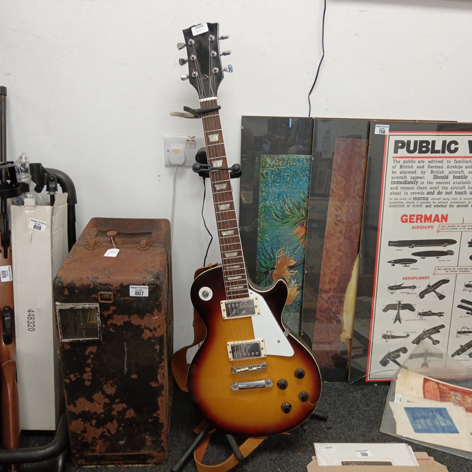 Vintage sunburst electric guitar with stand, classic musical instrument.