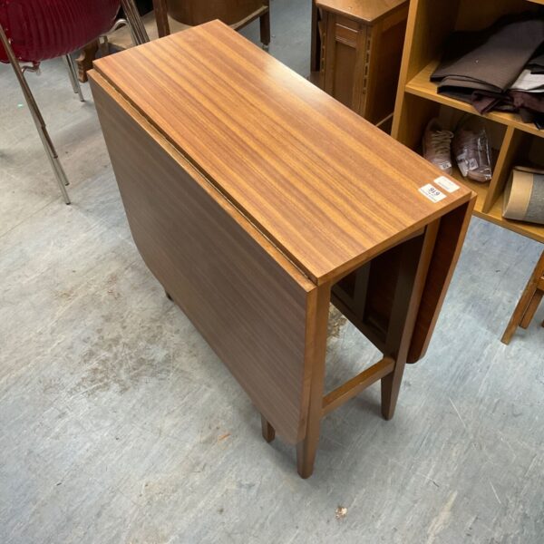 Vintage 1960s teak drop leaf table in a home setting.