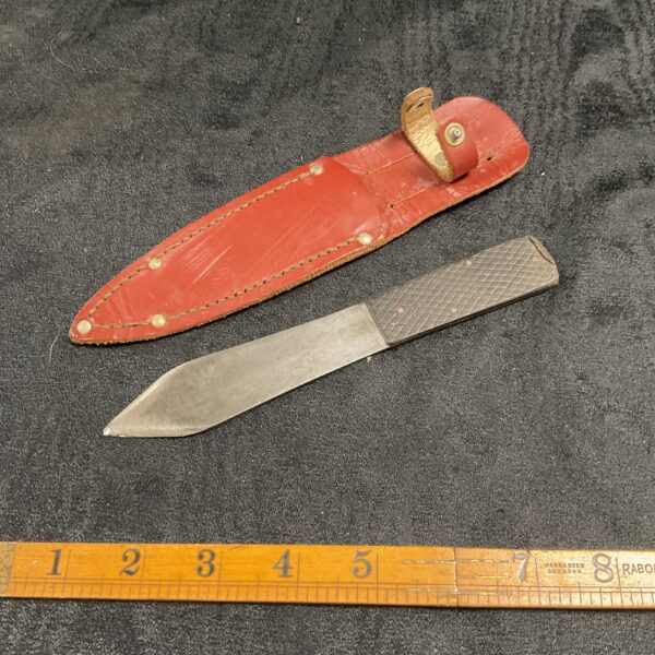 Vintage throwing knife with leather sheath, collectible blade.