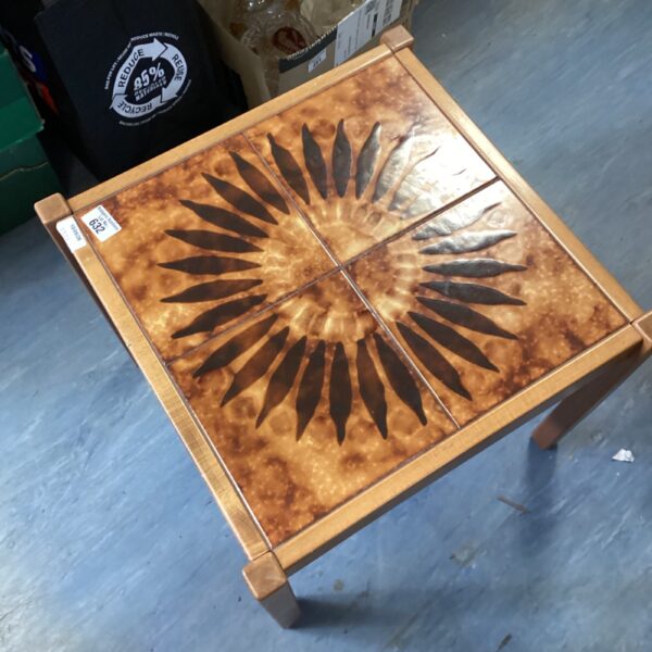 Vintage tile topped side table with sunburst ceramic design.