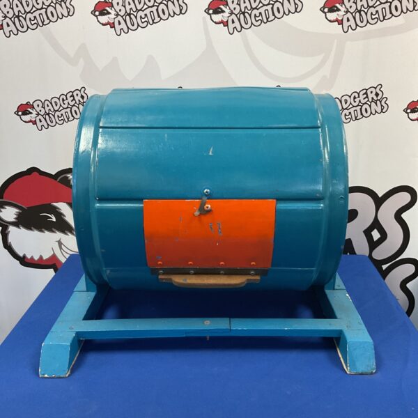Vintage red wooden tombola barrel for fairground games.