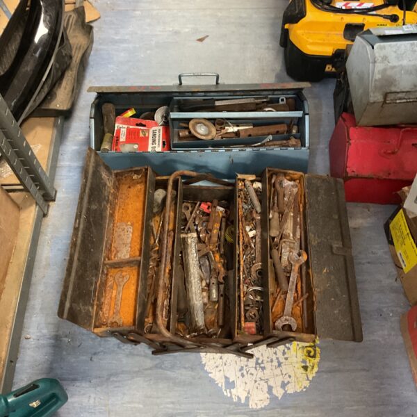 Filled vintage metal tool boxes with wrenches and screwdrivers.