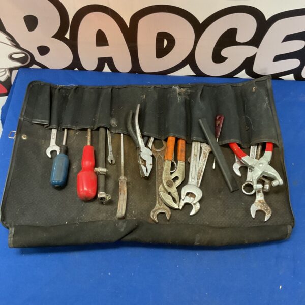 Vintage tool roll with wrenches, screwdrivers, and pliers.