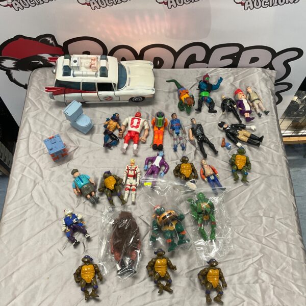 Vintage toy lot featuring Ghostbusters, He-Man, and Teenage Mutant Ninja Turtles figures.