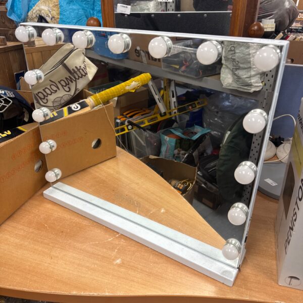 Vintage vanity mirror with lights and speakers, ideal for makeup application.