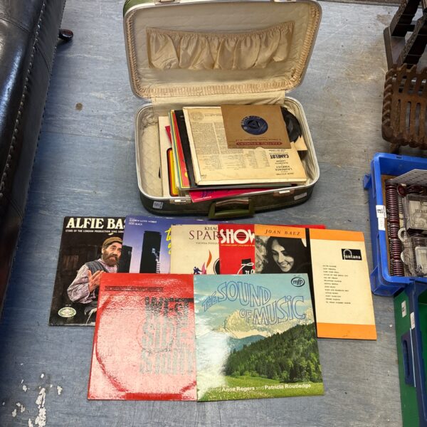 Vintage suitcase filled with a collection of vinyl records.